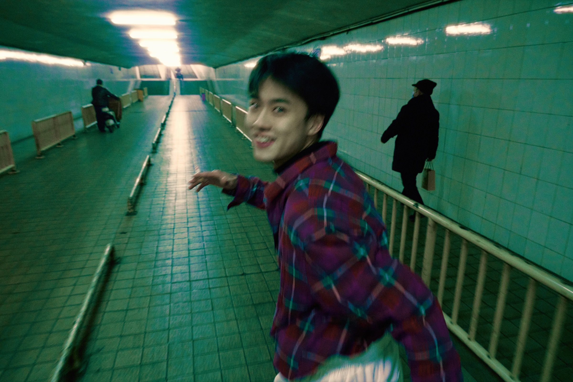 曾宇杰在地下通道里回头奔跑，画面带有运动模糊。